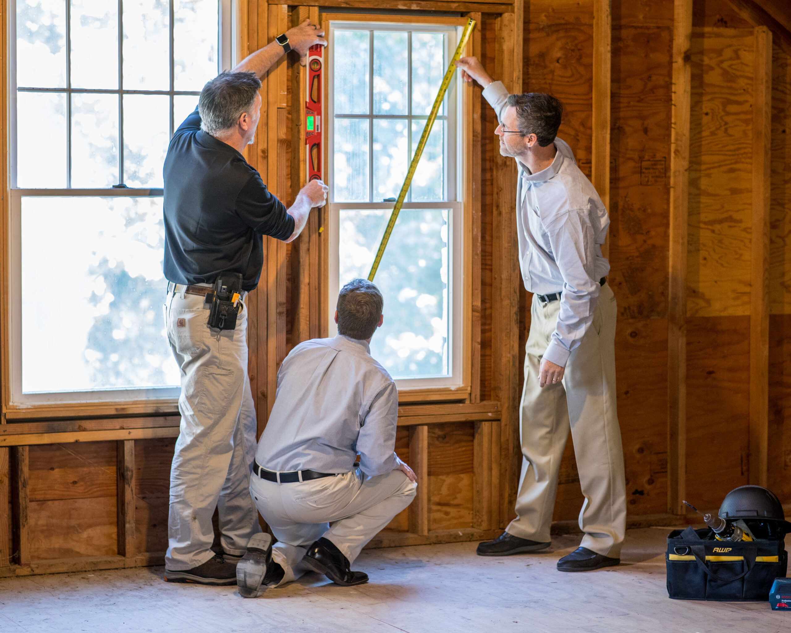Christopher D. Ling, AIA, NCARB, Ronald A. Mueller CSI, CCS, CCCA, and Mark Cable AIA take measurements on a job site.