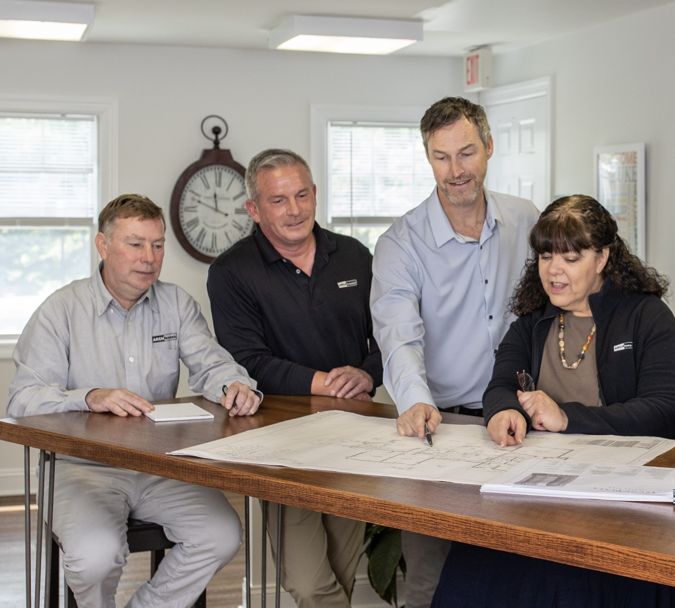 Christopher D. Ling, AIA, NCARB, Timothy P. Ronan, Mark Cable, AIA and Cindy Maselko reviewing architectural drawings and construction documentation in the office